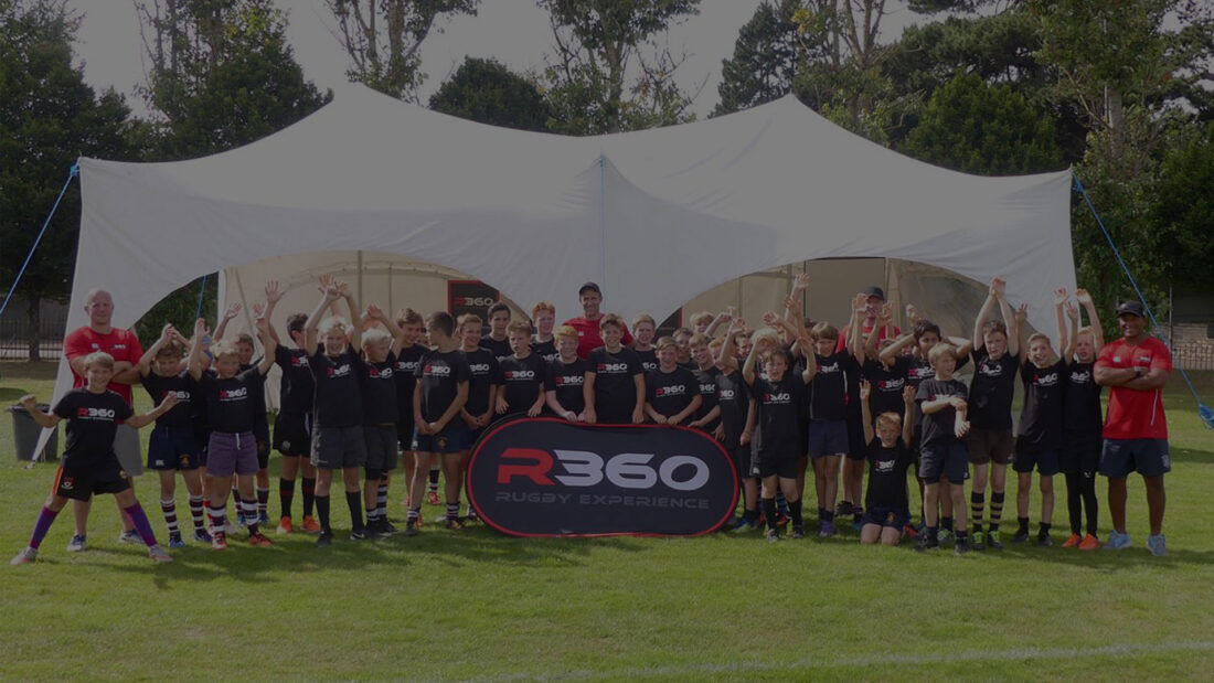 Young rugby players celebrating infant of a marqueee